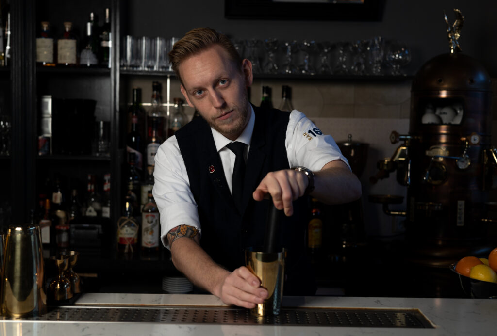 Mxologist Arjan, is bezig met het maken van een cocktail.
