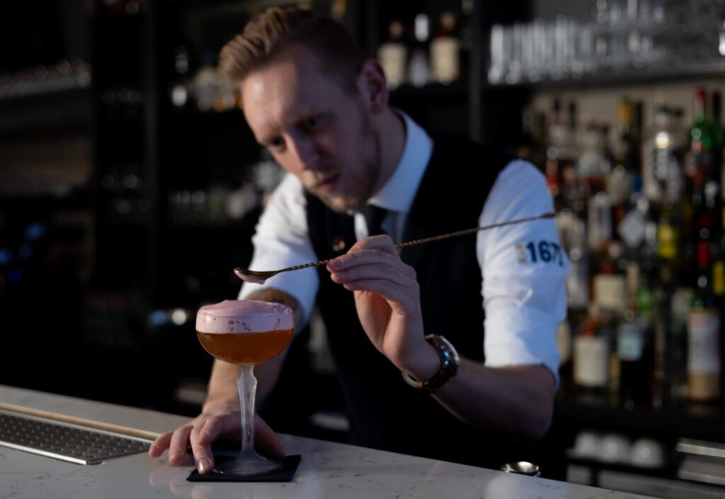 Mixologist Arjan, is bezig met het maken van een cocktail.