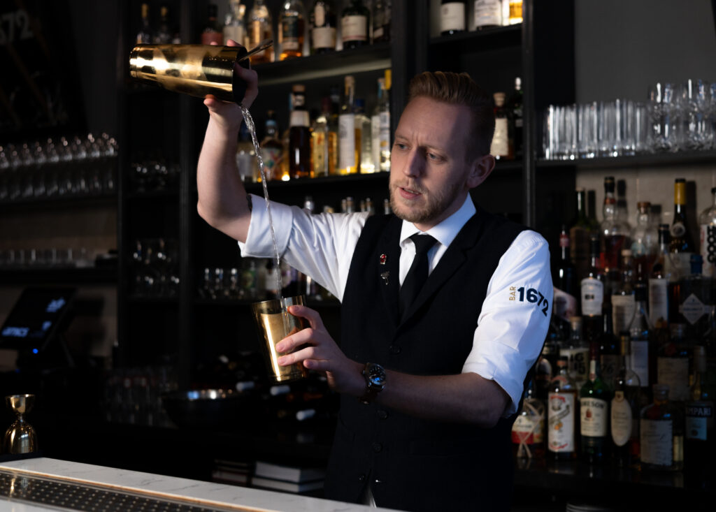 Mixologist Arjan, is bezig met het maken van een cocktail.